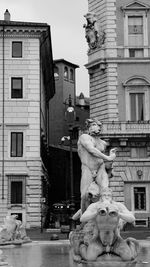 Statue against buildings in city