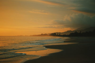 Scenic view of beach against sky during sunset