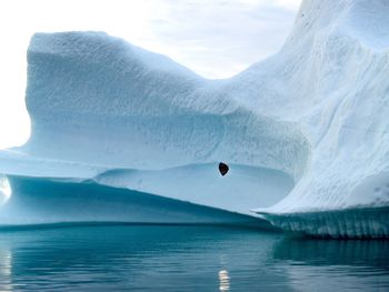 Lake and iceberg against sky