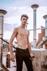 Portrait of young man standing against built structure