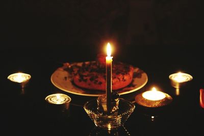 Close-up of lit candles in darkroom