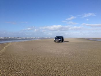 Car on beach against sky