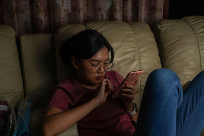 Rear view of woman sitting on sofa at home