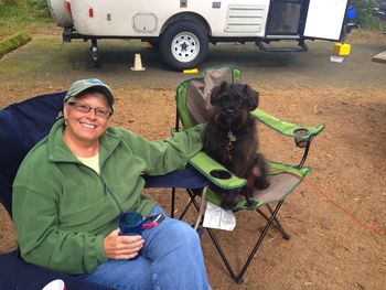 Portrait of woman sitting with dog by motor home