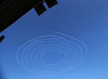 Low angle view of contrail at blue sky