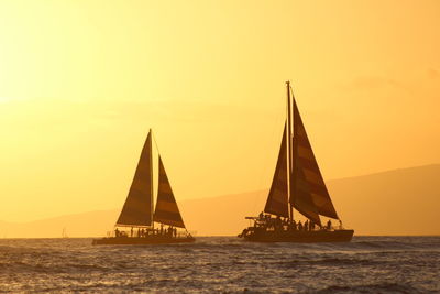 Scenic view of boats on sea at sunset