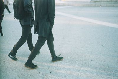 Low section of man walking on road