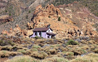 House on field by mountain