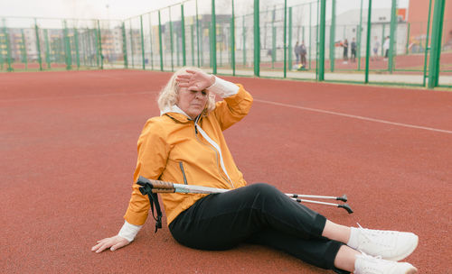 Mid adult woman sitting on floor against blurred background