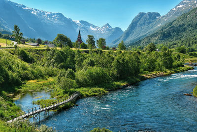 Scenic view of river by mountains against sky