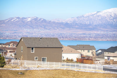 Houses by sea and mountains against sky