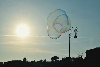 Low angle view of bubbles flying against sky at sunset