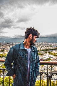 Young man looking at camera against sky