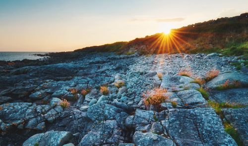 Beautiful sunset beach scape scenery of rocky coast at wild atlantic way in barna, galway, ireland