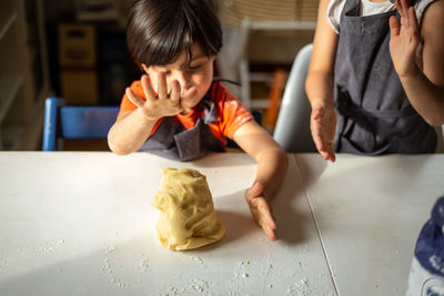 Dough prepared by two girls wearing grey aprons