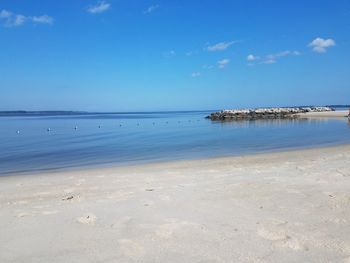 Scenic view of beach against blue sky