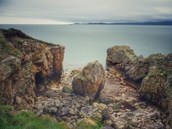 Rocks by sea against sky