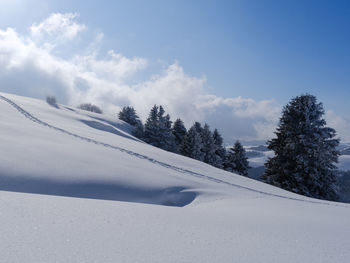 Snow covered landscape against sky