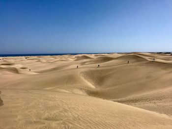 Scenic view of desert against clear blue sky