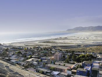 High angle view of buildings by sea against sky