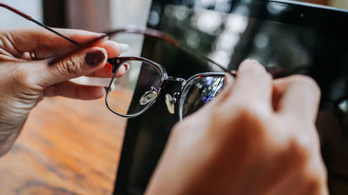 Close-up of woman hands holding eyeglasses