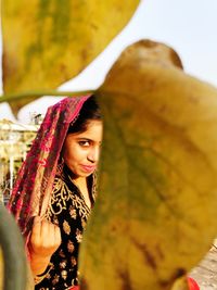 Portrait of woman wearing traditional clothing seen through leaves