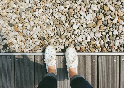 Low section of person standing on boardwalk