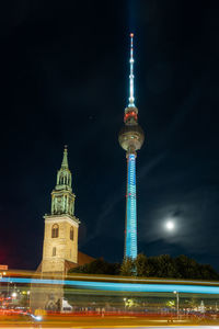 Illuminated buildings in city against sky at night