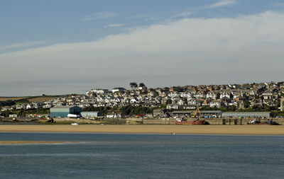 Scenic view of beach by buildings against sky