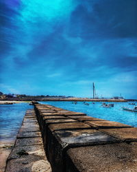 Pier over sea against blue sky