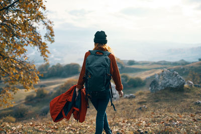 Rear view of man standing on land against sky