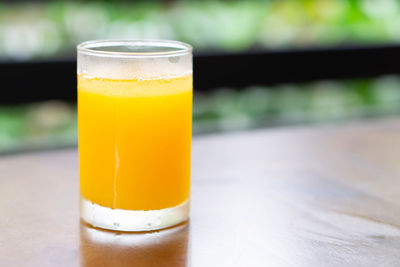 Close-up of orange juice in glass on table