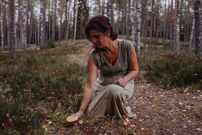 Woman holding wild mushroom in forest