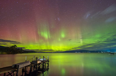 Scenic view of aurora australis southern lights over lake against sky at night