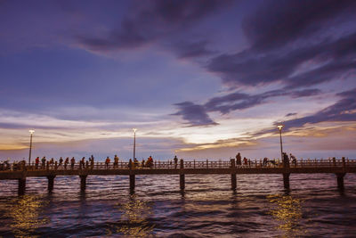 Pier on sea against cloudy sky