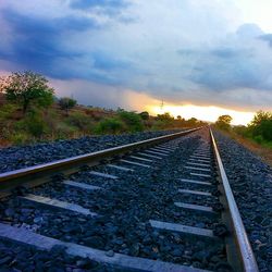 Railroad track against cloudy sky