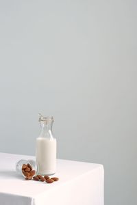 Close-up of glass bottle on table against white background
