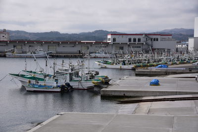 Boats moored in harbor by buildings in city