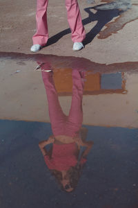 Low section of woman standing on puddle