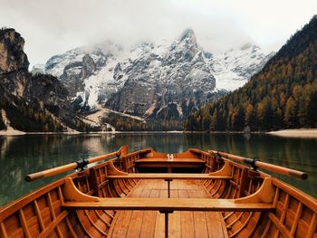 Boat in pragser wildsee against snowcapped mountain