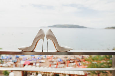 Close-up of high heels shoes on railing