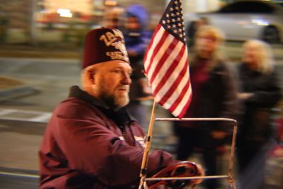 Rear view of man holding flag in city