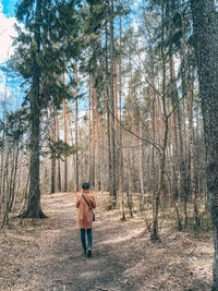 Rear view of woman walking in forest