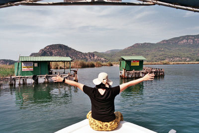 Rear view of man in lake against sky