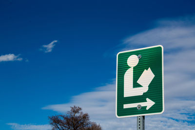 Low angle view of road sign against blue sky