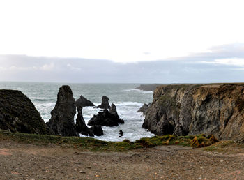 Scenic view of sea and cliff against sky