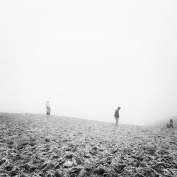 Man on beach against clear sky