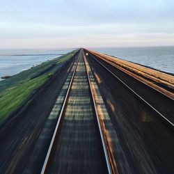 View of road by sea against sky