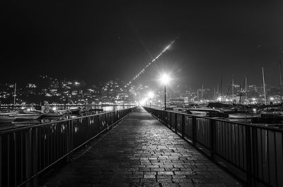 Illuminated bridge against sky at night