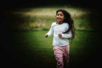 Smiling girl running in park